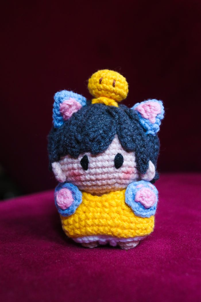 Crochet doll with a tiny yellow bird
