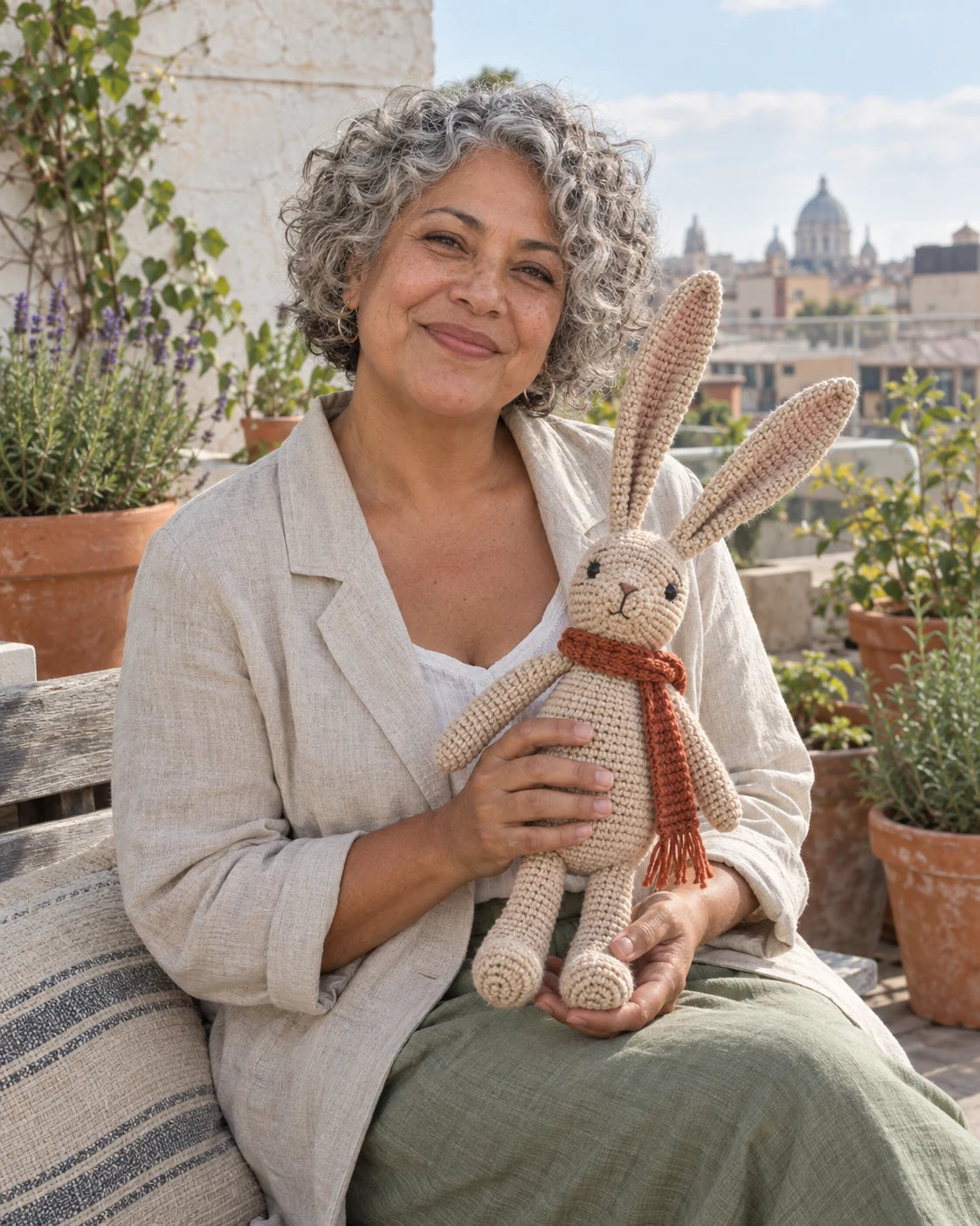 Fictional Woolspell maker in a rooftop garden holding an oatmeal crochet hare concept